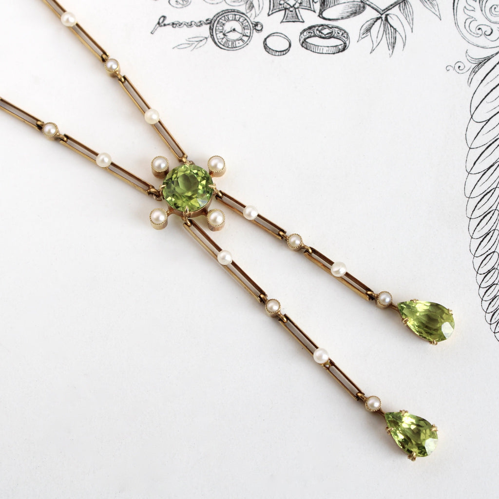 Antique yellow gold negligee style necklace with two peridot teardrops on bard chain link studded with tiny pearls, and a round peridot at the center.