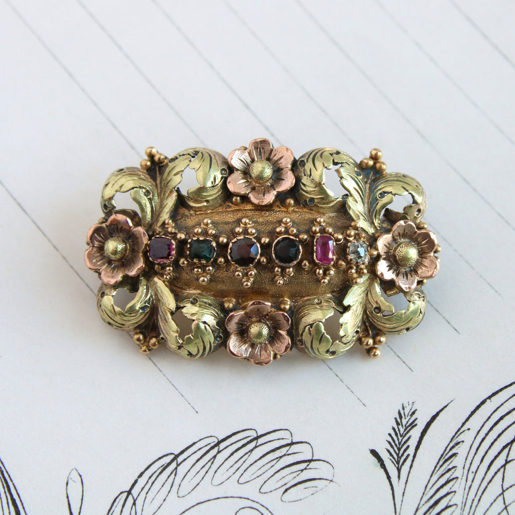 Antique two tone gold floral plaque design brooch set with an array of faceted gemstones.