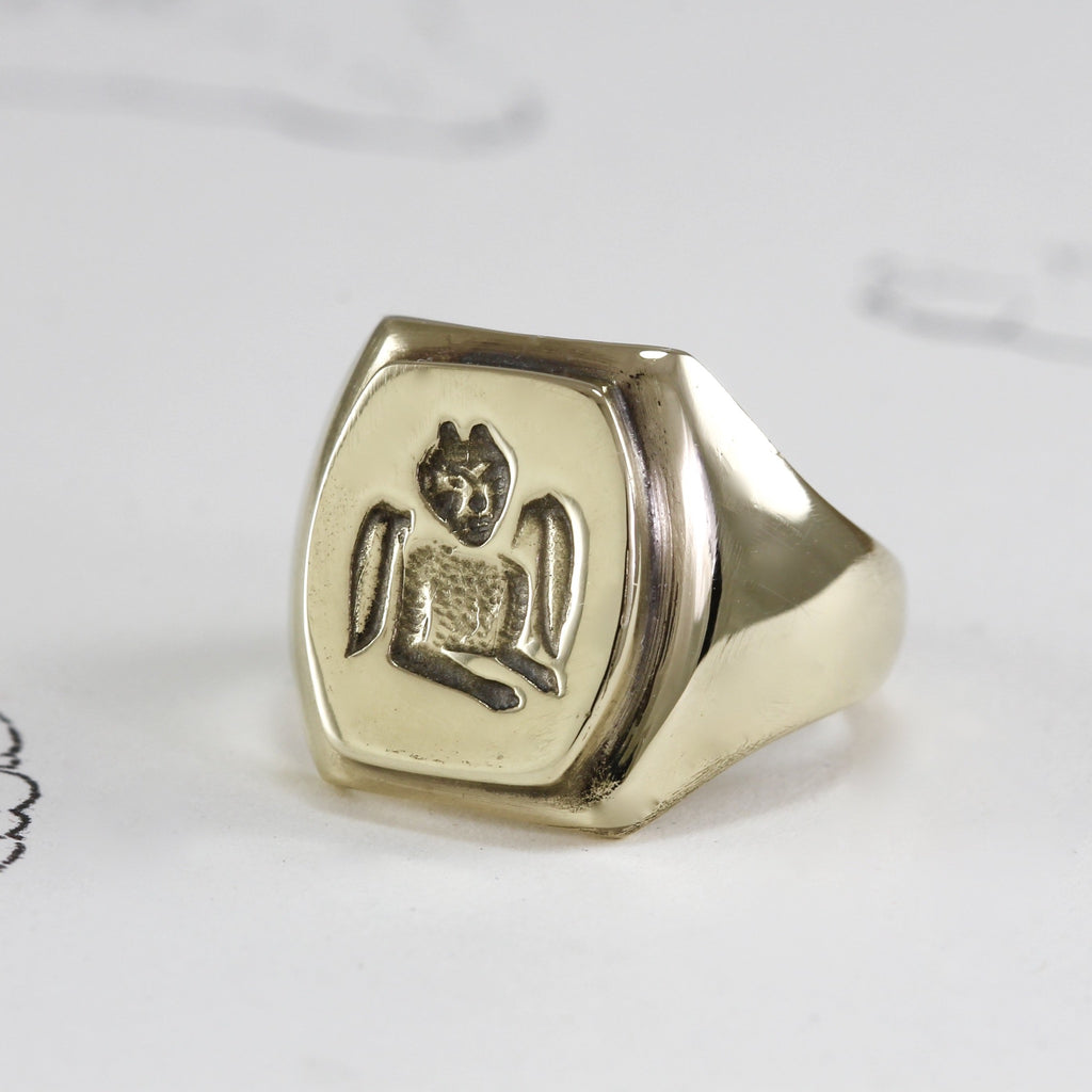 Handmade yellow gold square signet ring with devil engraving on the front.