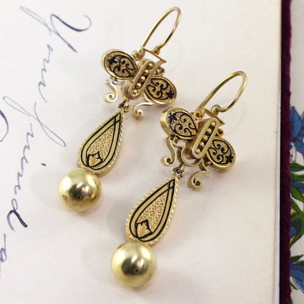 Antique yellow gold earrings in Taille d’Épargne style with hook posts and black enamel detailing.