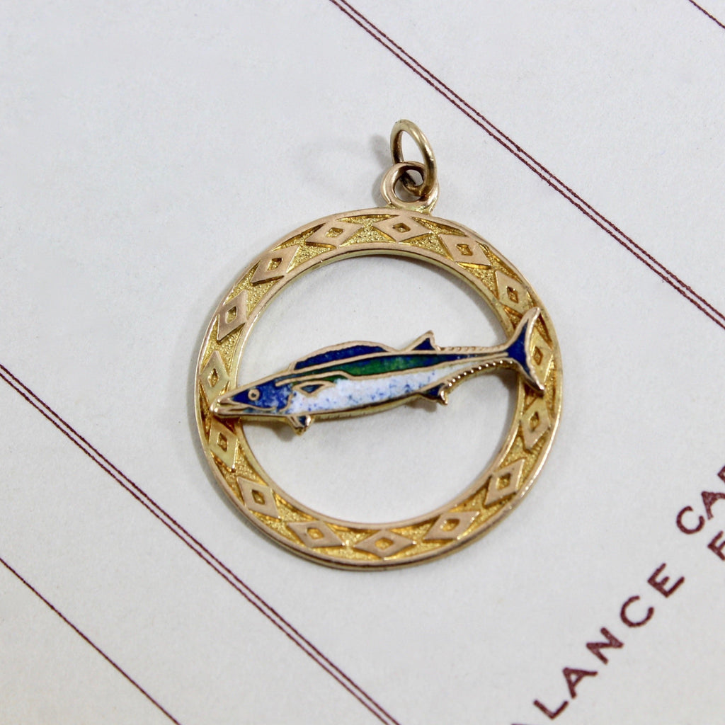 Vintage yellow gold charm with a tropical fish realistically enameled in shades of blue, green and white circled by a yellow gold border.