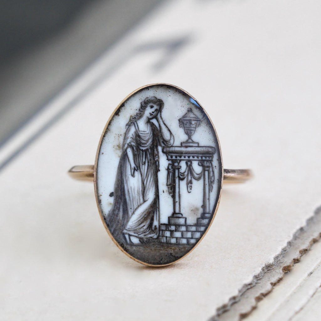 Antique yellow gold ring with an oval cabochon with a miniature painting of a woman in a flowing dress.