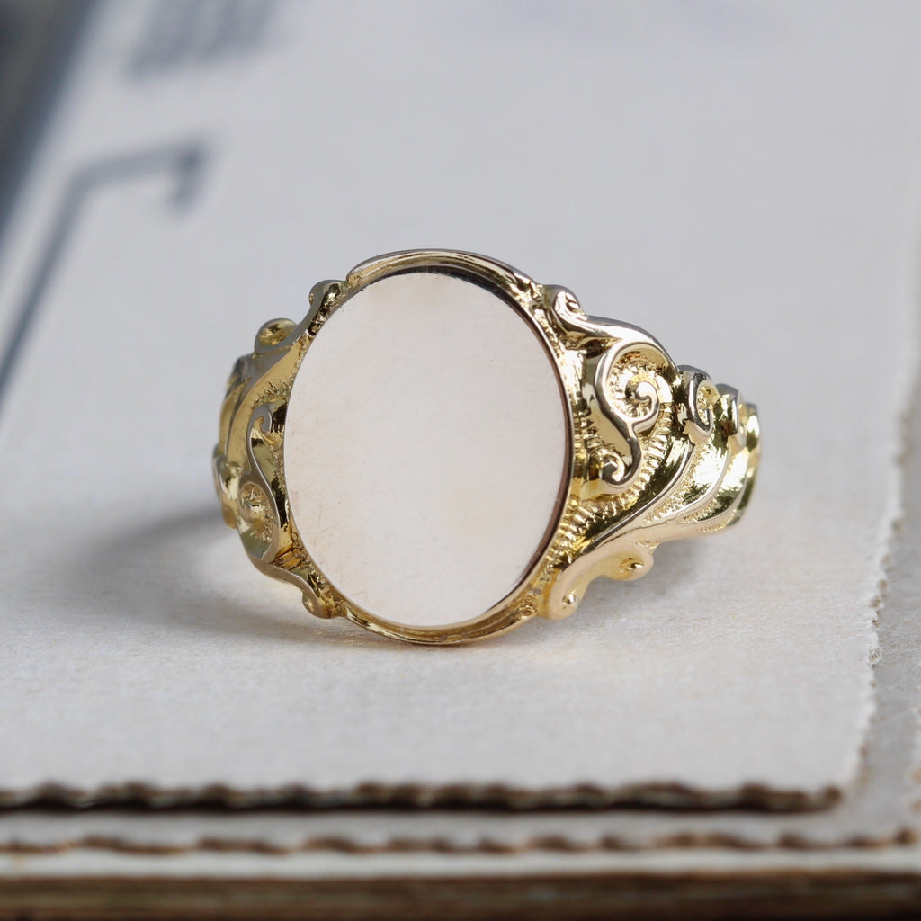 Vintage yellow gold signet ring with scroll designs around the band with high polish finish.