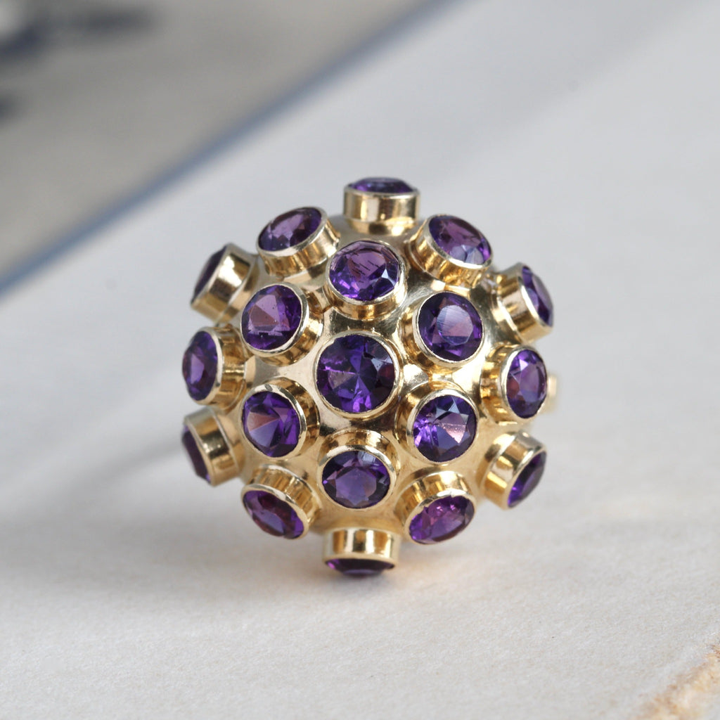 Vintage 18k yellow gold dome cocktail ring with faceted amethyst studs covering the face.